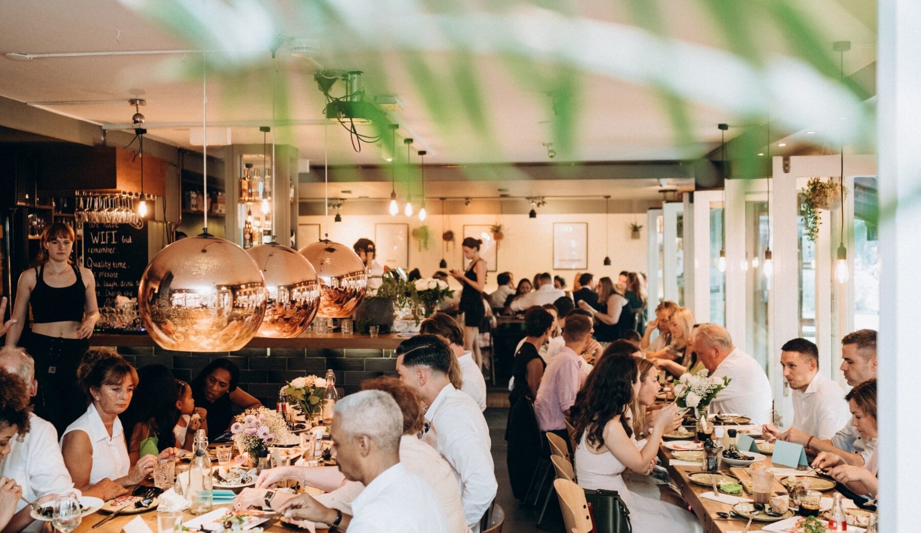 Een lange gedekte tafel vol gasten tijdens een proeverij bij Nassau